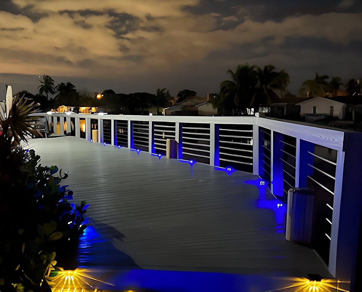 Illuminated waterfront deck at night with blue LED rail accent lights — South Florida by Contour Marine