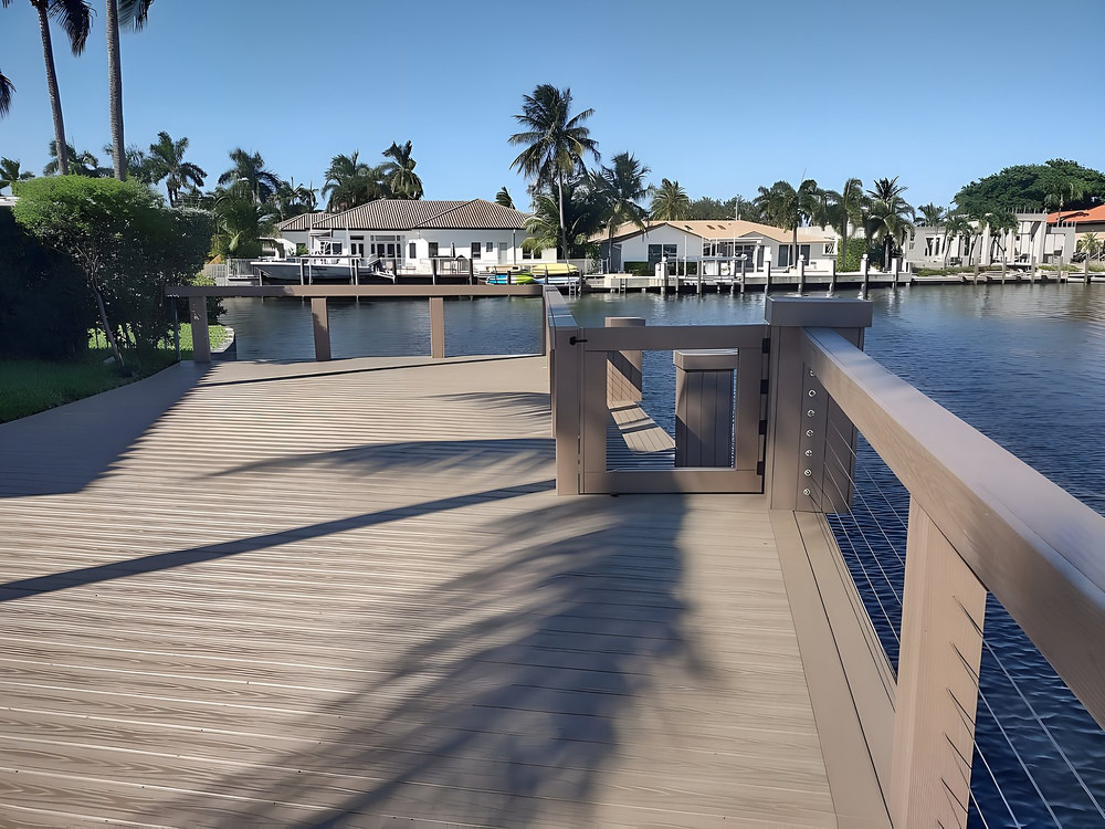 Grey composite dock with stainless cable railing and gate — South Florida canal by Contour Marine